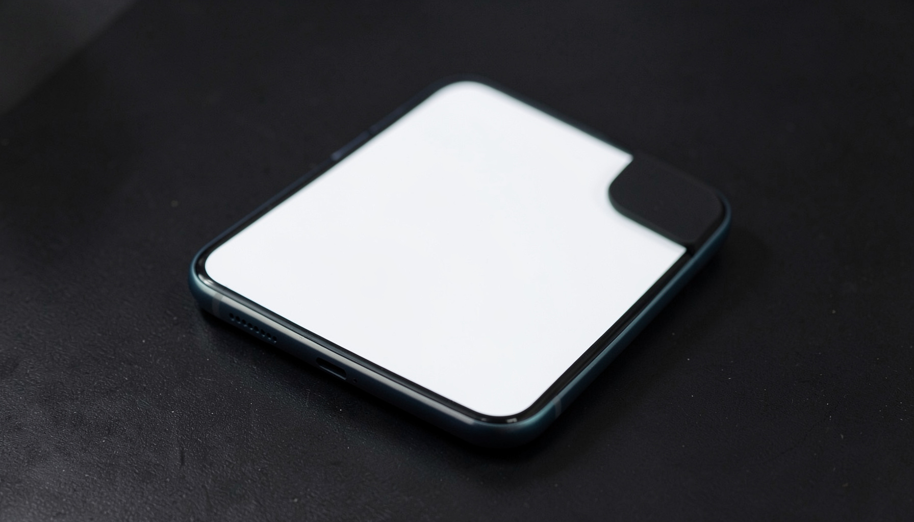 Smartphone clone device with a familiar design language, white front face, on a dark desk